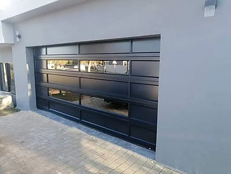 Aluminium full-view garage door with glazed panels on a modern home