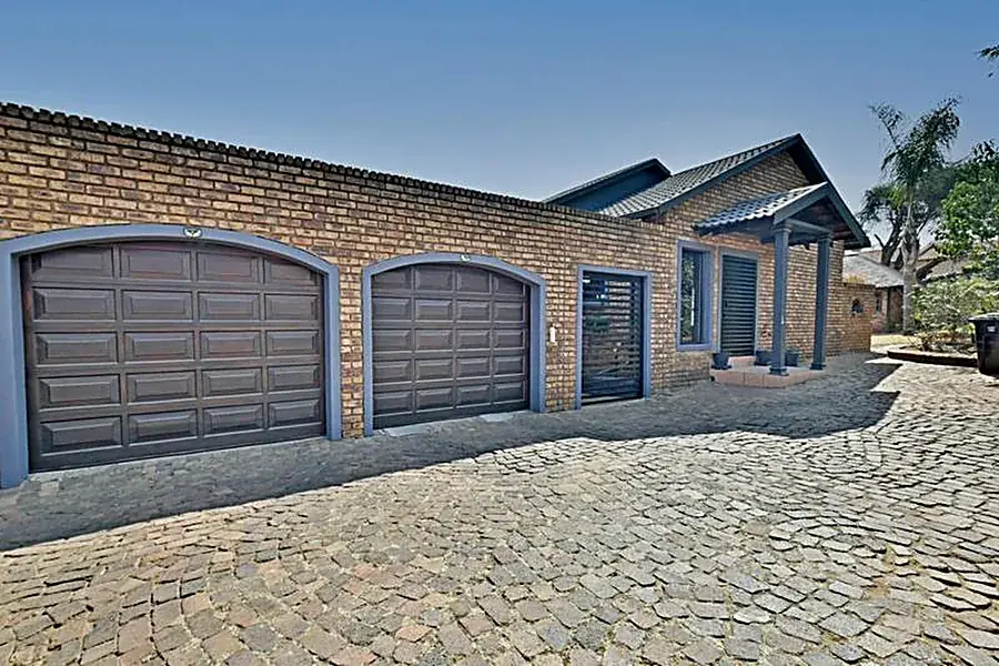 Arched wooden garage doors on a Gauteng home fitted by Clearpath Garage Doors